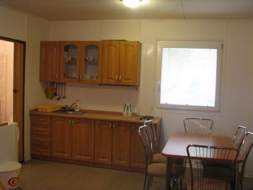 cocina con armarios de madera, mesa y ventana en Kemp Horní Bečva, en Horní Bečva