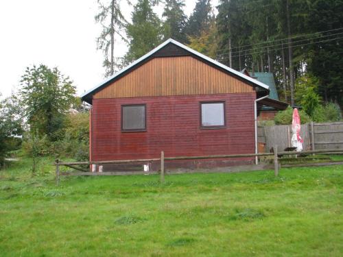 una pequeña casa roja en un campo de hierba en Kemp Horní Bečva, en Horní Bečva