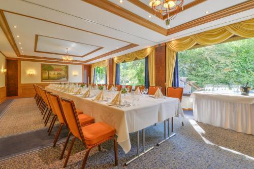 a long dining room with a long table and chairs at Hotel Zur Mühle in Bad Brückenau