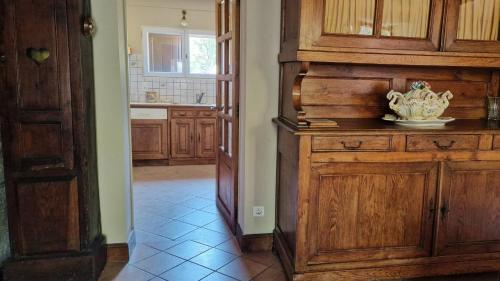 a kitchen with a large wooden cabinet in a room at Le Gite de la Ferme d Issac in Le Nayrac
