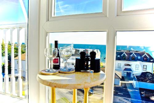 a table with wine bottles and glasses in a window at Poltair Guest House in Falmouth