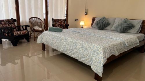 a bedroom with a large bed with a blanket on it at Aralu in Bangalore