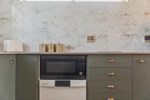a kitchen with a counter top with a microwave at Lloyd's Corner in Cape Town