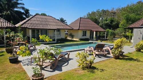 a villa with a swimming pool in a yard at CharPoot Cottage Khao Lak in Khao Lak