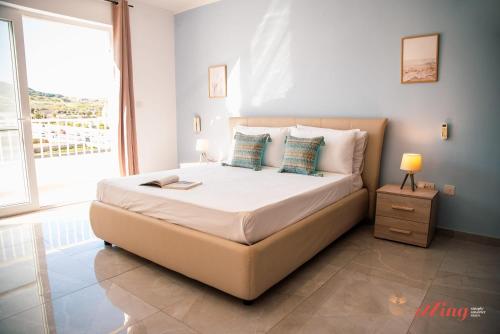 a bedroom with a large bed with a large window at Pretty Beachfront Penthouse in Mellieha in Mellieħa