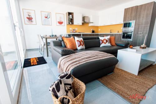 a living room with a couch and a kitchen at Pretty Beachfront Penthouse in Mellieha in Mellieħa