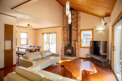 a living room with a couch and a table at 2 minutes from Kugino Station Aso Mountain View, Villa with Heater in Minami Aso