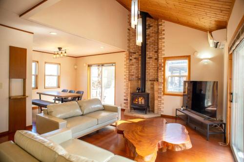 a living room with a couch and a fireplace at 2 minutes from Kugino Station Aso Mountain View, Villa with Heater in Minami Aso