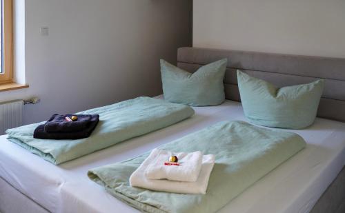 two towels on a bed with pillows on it at Ferienwohnung Vögel in Langenegg