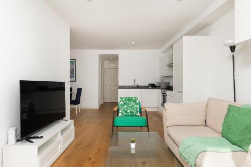 a living room with a couch and a tv at New! Bright 2BR Flat with Patio in Elmers End