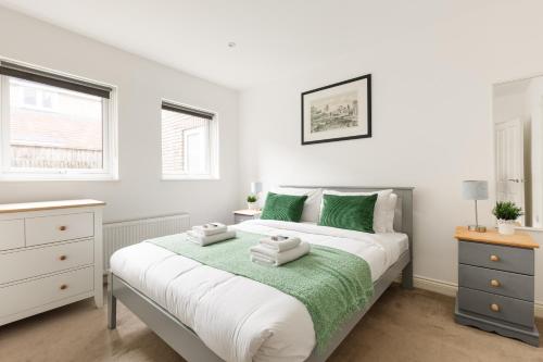 a bedroom with a bed with towels on it at New! Bright 2BR Flat with Patio in Elmers End