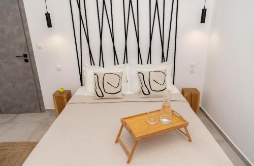 a bed with white pillows and a wooden table at Casa De Lago in Agios Nikolaos