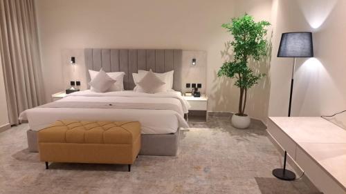 a large bedroom with a large bed and a chair at Triple A Hotel in Riyadh