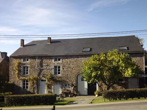 una casa de piedra con un árbol delante en B&B Le Secret Du Bois en Bourseigne-Vieille