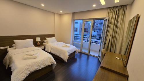 a hotel room with two beds and a balcony at Maison 7 New Cairo in Cairo