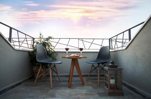 a balcony with two chairs and a table with a sky at Hotel Cura in Canakkale