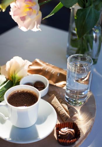a cup of coffee and a glass of water on a table at Hotel Cura in Canakkale