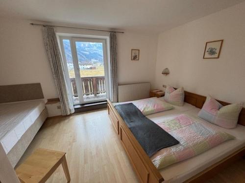 a bedroom with two beds and a large window at Ferienwohnung Garber in Uderns