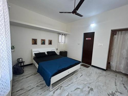 a bedroom with a bed with a blue blanket at Grey Pearl Homestay in Pondicherry