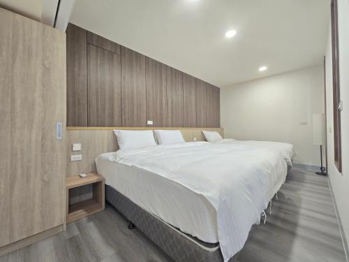a bedroom with a large bed with a wooden wall at 悠而行旅 in Nangan