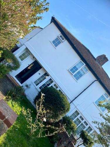 a large white house with windows on it at Garden Lodge, boutique - Walton on Thames in Walton-on-Thames