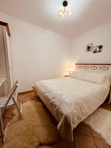 a white bedroom with a bed and a lamp at Andrei's house in Sinaia