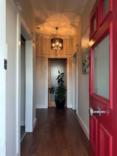 a hallway with a red door and a potted plant at Alvane Cottage in Goulburn