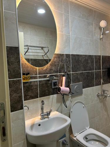 a bathroom with a sink and a toilet and a mirror at loopy lodge hotel in Ürgüp
