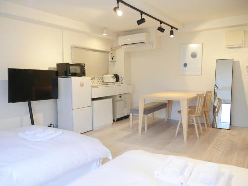 a room with a kitchen and a table with a tableablish at 9STAY Shibuya Shinsen in Tokyo