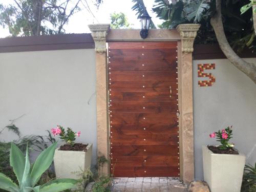 a wooden garage door with two potted plants at The Buddha Garden in Cape Town