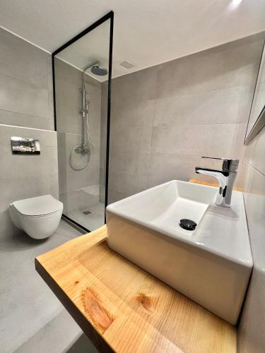 a bathroom with a white sink and a toilet at Casa De Lago in Agios Nikolaos