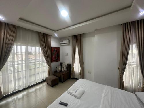 a bedroom with a bed and two large windows at B-12 Apartments in Lagos