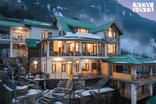a house in the mountains with snow at Stayvista at Tulip Terraces Cozy Mountain Home with Fireplace in Manāli