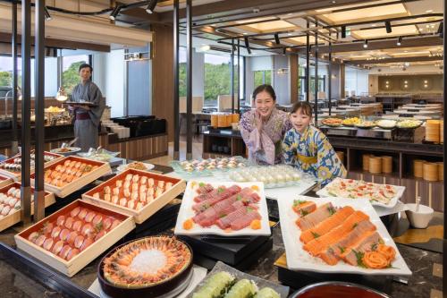 two children standing in front of a buffet of food at Ooedo Onsen Monogatari Premium Shima Saichoraku in Shima