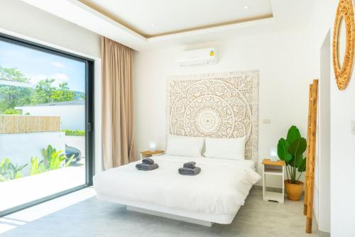 a bedroom with a bed and a large window at Villa Laura 2Br & Private Pool in Mae Nam in Mae Nam