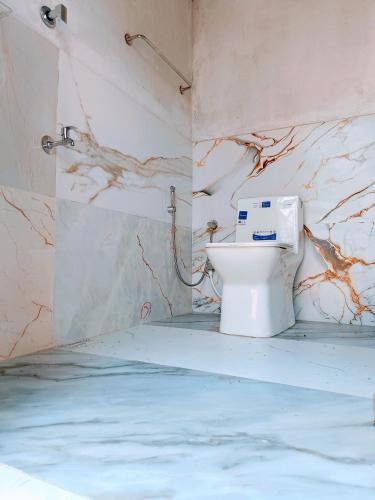 a bathroom with a toilet in the corner of a room at Gandhara Tent camping in Vagamon