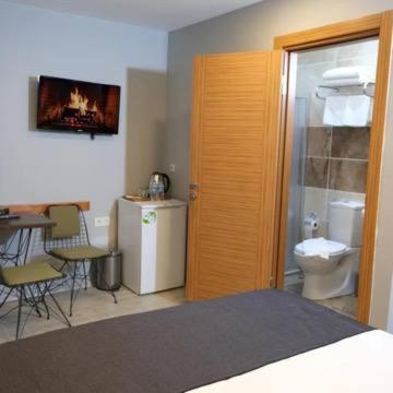 a bedroom with a bed and a table and a toilet at Ore Pera Suites in Istanbul