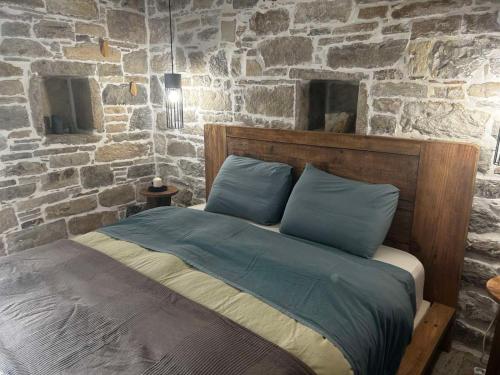a bedroom with a bed with a stone wall at Petrino Minimal in Dhéndra