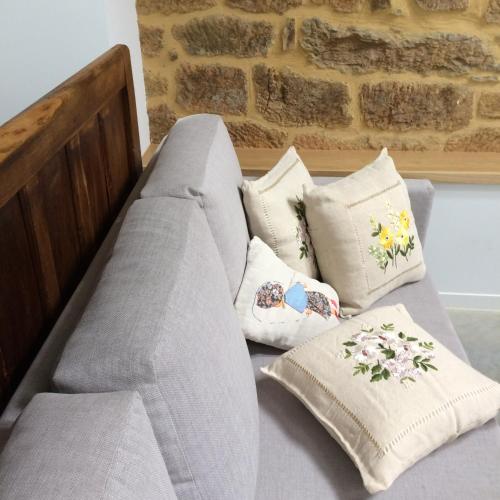 a couch with pillows on it in a room at Casa la Devesa de Sanabria in Remesal