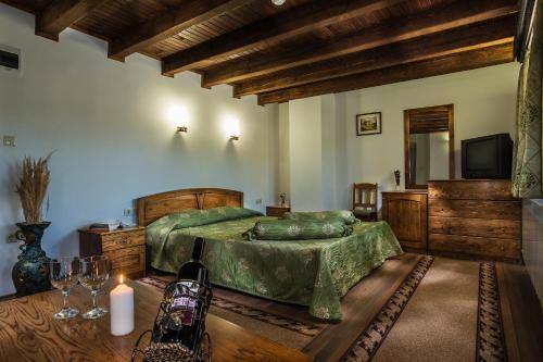 a bedroom with a bed and a television and a table at Elenski Riton Complex in Sredni Kolibi