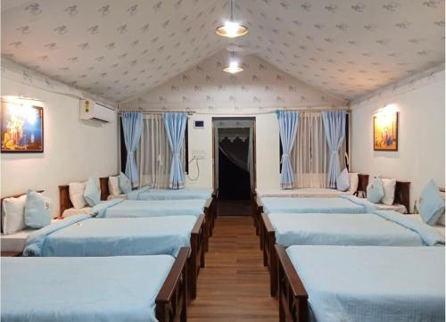 a row of beds in a room at Gaudham Periyar Farms in Jambhulpāda