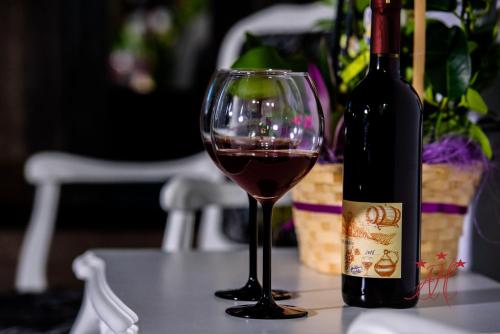 a glass of wine sitting next to a bottle of wine at Alexander House in Deva