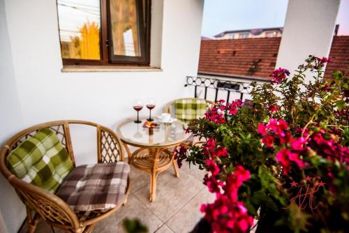 a patio with a table and chairs and flowers at Alexander House in Deva