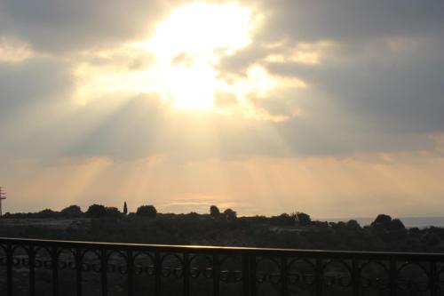 a sun shining through the clouds in the sky at Benichuta in Mitzpe Hila