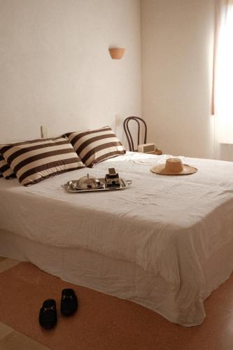 a bedroom with a white bed with shoes on it at La Molina Mallorca in Felanitx
