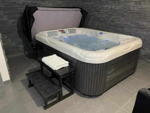 a jacuzzi tub with a stool in a room at Le pont des rêves in Pont-sur-Sambre