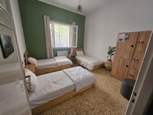 a bedroom with three beds and a window at Nomads Hostel Sousse in Sousse