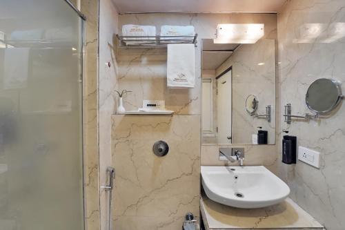 a bathroom with a sink and a shower at Palette Orient Hotel & Convention Centre by CheckIn, Nagpur in Nagpur