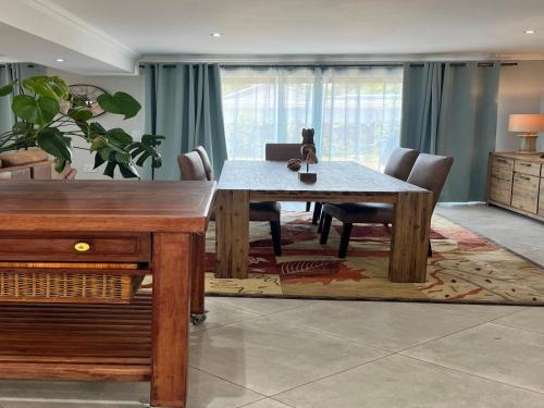 a dining room with a wooden table and chairs at Comfort Cove in Pretoria