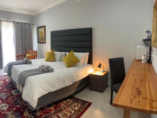 a bedroom with a large bed and a wooden table at Comfort Cove in Pretoria